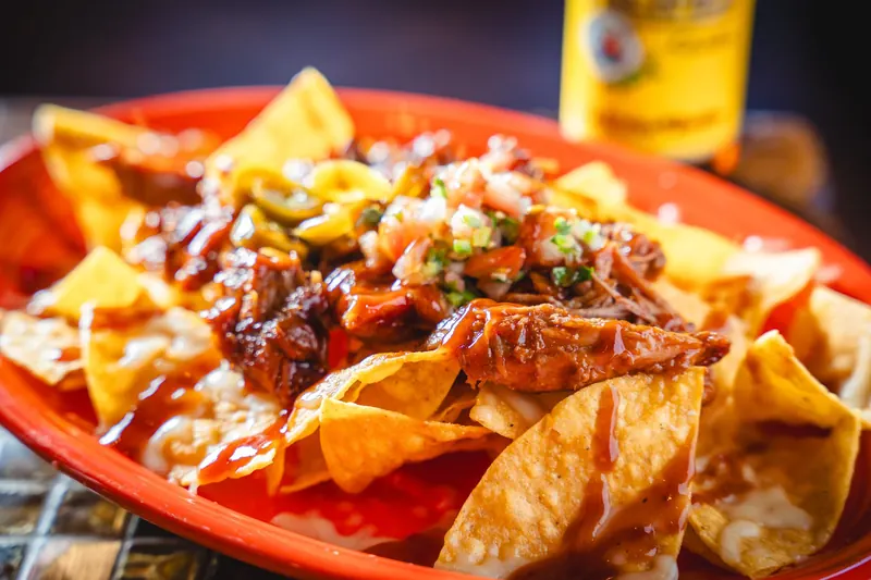 BBQ Nachos on a red-orange platter