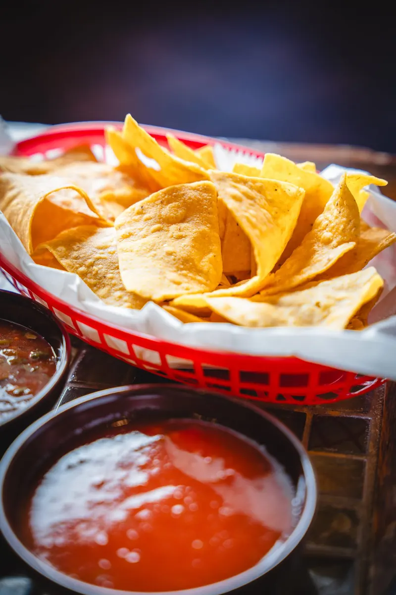 Basket of tortilla chips with red salsa