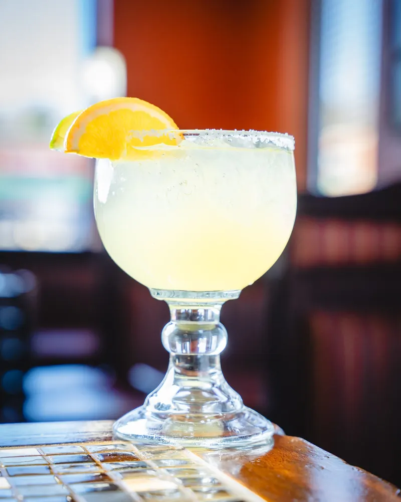 House margarita with an orange slice and salted rim