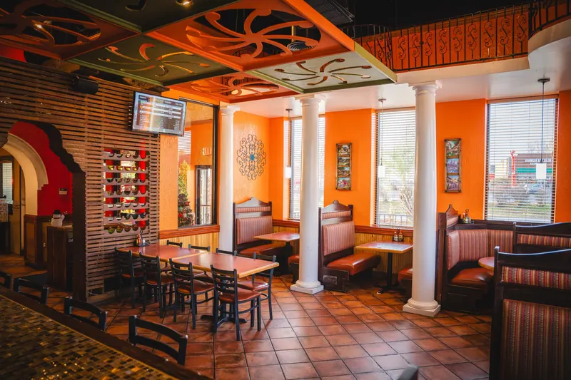 Monroe dining room with orange walls, booths and white columns